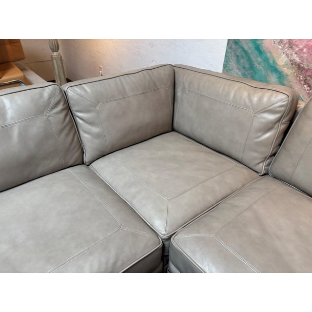 A luxurious Bernhardt leather sectional upholstered in supple dove-gray leather with elegant nailhead trim and rolled...