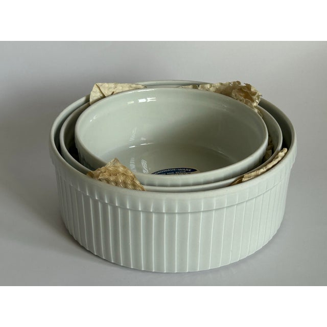 Set of three vintage Pillivuyt French porcelain soufflé dishes with classic deep pleated sides and a soft white glaze....