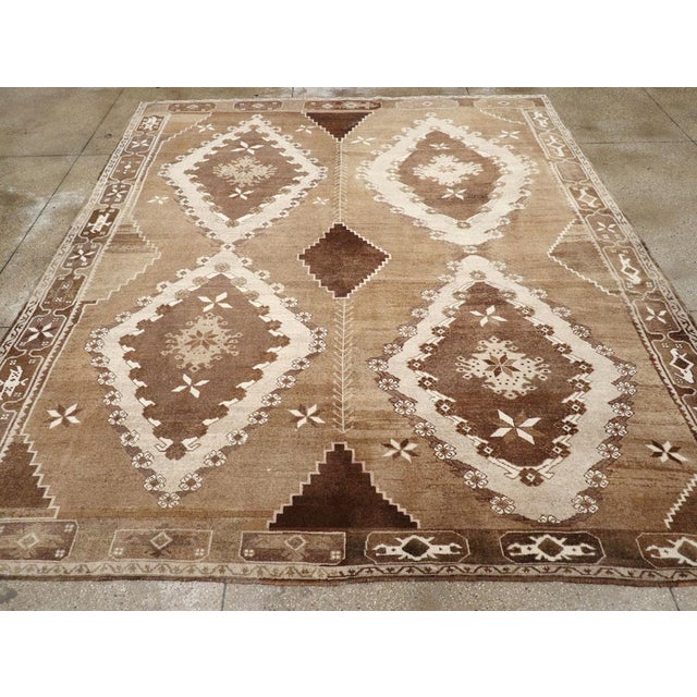 A Wool pile with symmetric knots on a wool foundation. The soft brown field, significantly abrashed, is notched at the...
