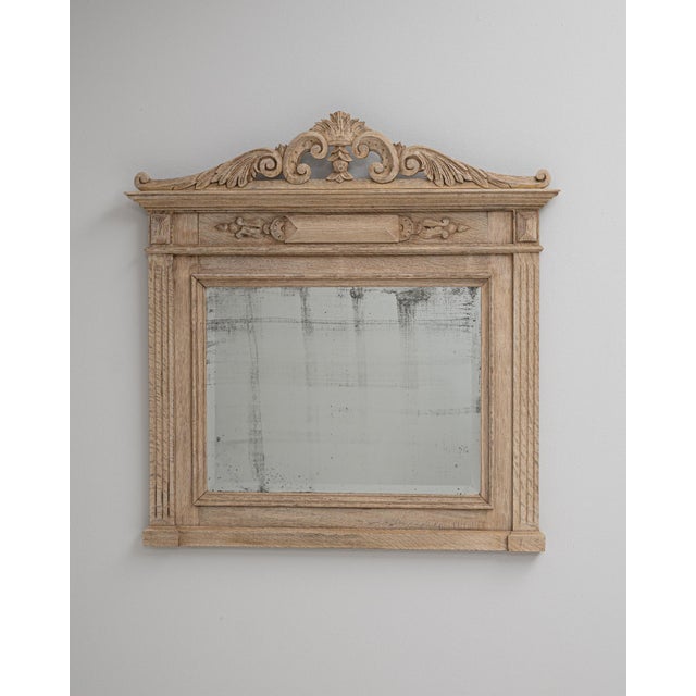 This 1900s French oak wall mirror reflects the refined craftsmanship and understated elegance of early 20th-century...
