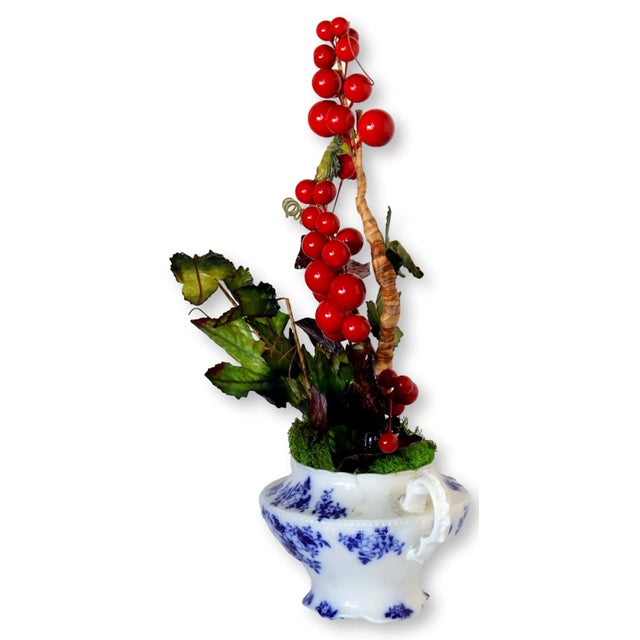 An exquisite 19th-century English flow blue porcelain sugar bowl, transformed into a timeless holiday arrangement. The...