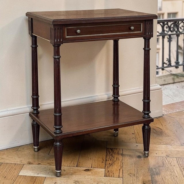 Refined French Louis XVI style gives this mid-century mahogany end table its timeless appeal. The clean neoclassical...
