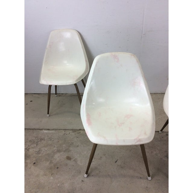 This set of 4 mid century modern chairs feature molded plastic construction, unique white and pink design, and swivel base...