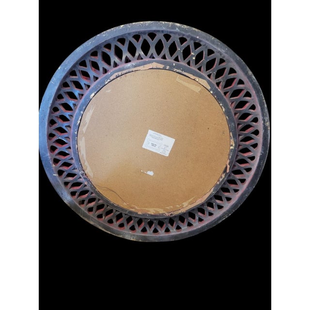 A beautiful very large round wall mirror custom painted in a bright glossy red. The mirror features a lattice design in a...