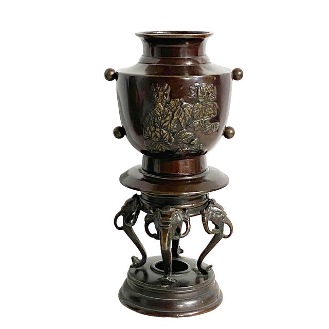 An exceptional vintage Japanese bronze ceremonial incense burner featuring four elephant trunk legs adorned with peony...