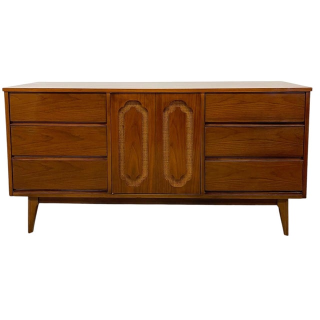 Vintage mid century modern credenza featuring a clean, linear profile elevated on tapered legs. The case is finished in a...