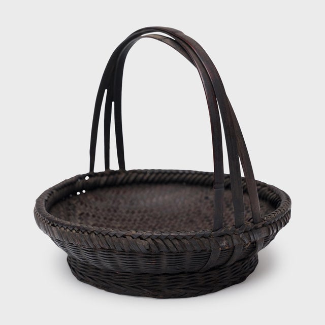 Woven with precious scale and delicate artistry, this small flower basket from the early 20th century is a lovely example...