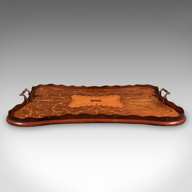 This is an antique butler's serving tray. An English, mahogany afternoon tea platter with ornate boxwood inlay, dating to...