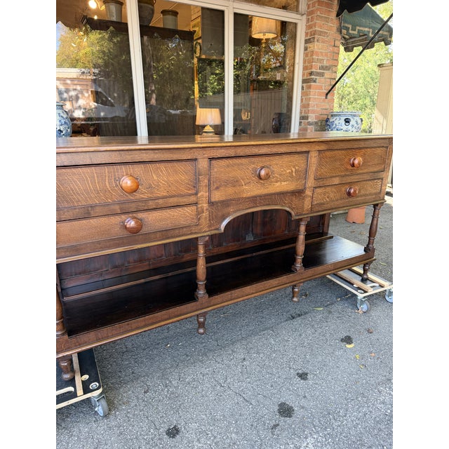 This is an attractive Welsh Dresser base with rectangular top over 5 drawers with elegant turned leg supports over...