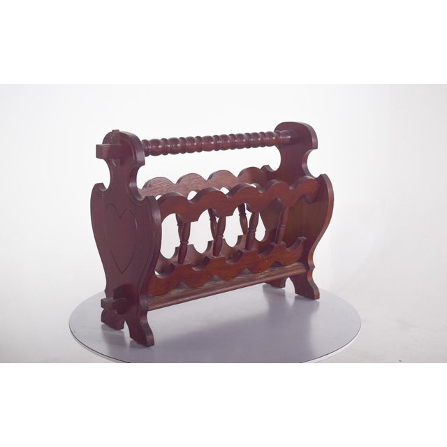 Wooden magazine rack, with turned details. It has four external columns turned in a spiral, with simpler vertical rods...