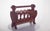 Wooden magazine rack, with turned details. It has four external columns turned in a spiral, with simpler vertical rods...