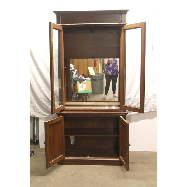 Traditional wooden china cabinet prioritizing clean lines and a functional geometric appearance. Small lower cabinet with...