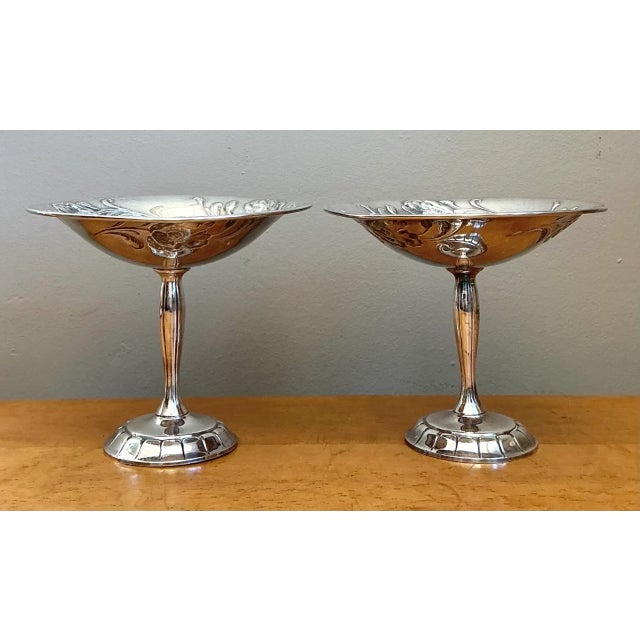 Showcasing graceful proportions and organic naturalistic detailing, this pair of vintage silverplate compote dishes...