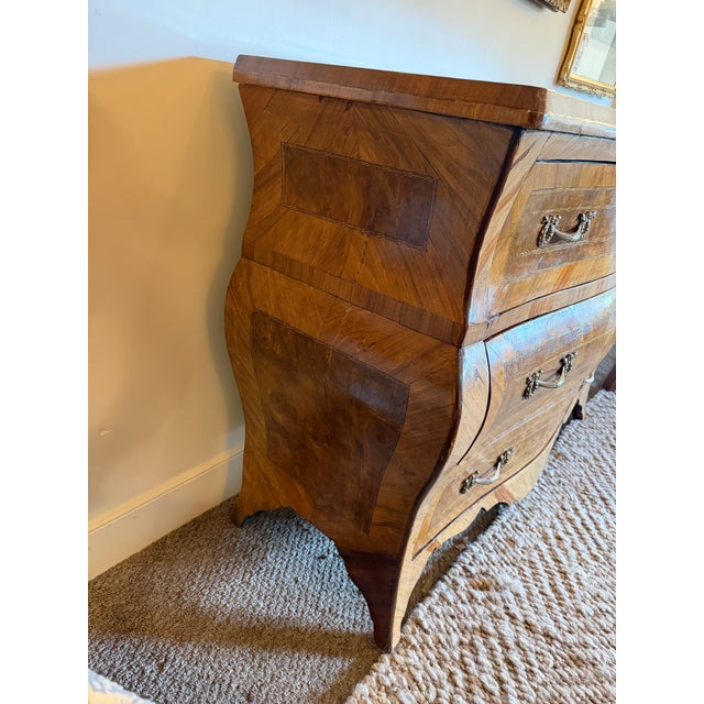 Masterfully crafted, the chest showcases a dramatically contoured, serpentine facade and gently swelling bombé sides,...