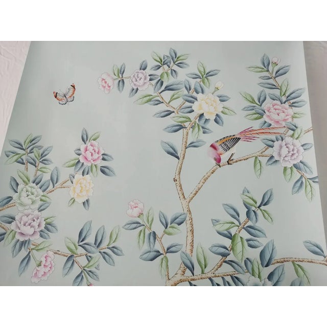 This hand painted Chinoiserie-style wallpaper mural features elegant flowering branches, delicate birds, butterflies, and...