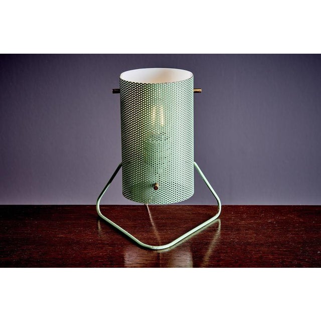 A pair of mid-century table lamps by stilux milano, each with a cylindrical shade made from perforated metal and a smooth...