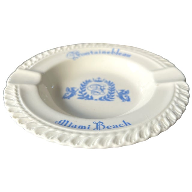 A refined mid-century porcelain ashtray from the iconic Fontainebleau Hotel, Miami Beach. Rendered in crisp white with...