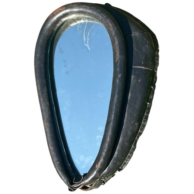 A vintage mirror crafted from an authentic horse harness collar, repurposed into a striking piece of American equestrian...