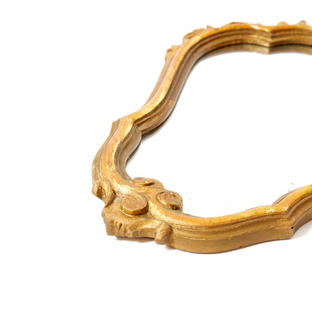 Pair of mirrors. Hand carved Swiss pine wood, gold plated frame finished with agate stone. The decorations are gilded and...