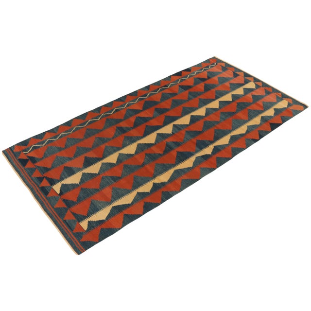 Handwoven in wool, a 5×10 vintage Baluch Kilim originating circa 1950-1960 among our curations of the finest Persian...