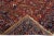Beautiful antique Heriz hand-knotted wool rug with a red field. This Heriz rug has a navy blue frame and multi-color...