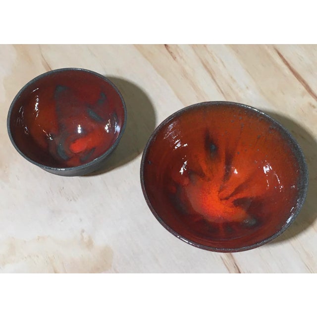 A pair of vintage modernist studio ceramic bowls by Oscar Bucher (Santa Barbara, CA). These have a wonderful orange/ red...