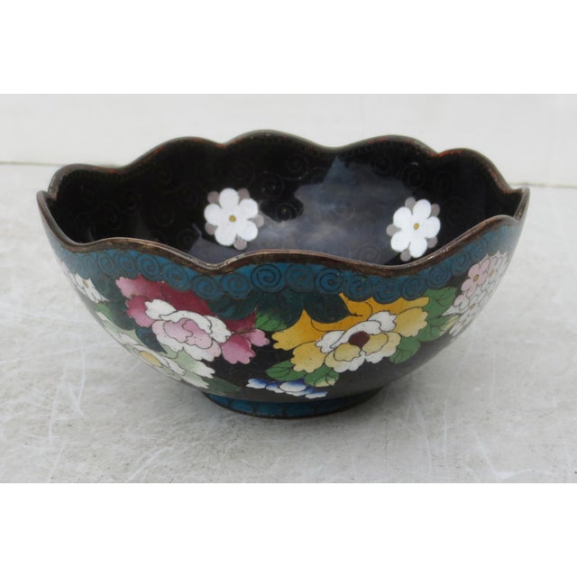 Chinese Enamel bowl, rolling rim design with a blue border and cascade of flowers descending from the rim. The bottom edge...