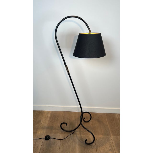 This beautiful floor lamp with an interesting design is made of black lacquered metal and brass. It is a French work in...