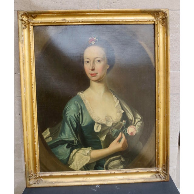 18th century Scottish school Portrait of a Lady. A formal portrait set in an oval window and holding fresh flowers in her...