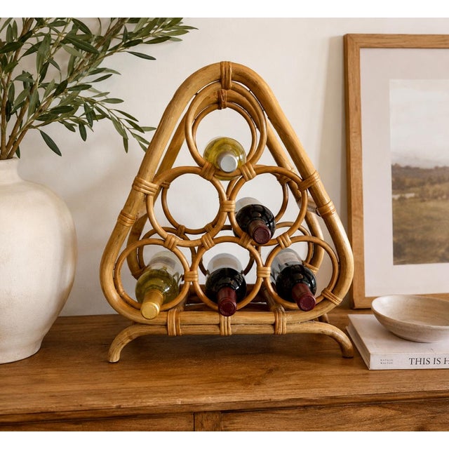 Add organic texture and sculptural charm to your space with this vintage rattan and bamboo wine holder. Featuring an eye-...