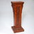 Tall pedestal with a front-facing side and a rectangular platform (46 x 24 cm). The pedestal rests on a profiled base and...