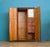 A 1950's compactum double wardrobe in ribbon-grain mahogany veneer. Plain front with central lock and stepped plinth. Left...