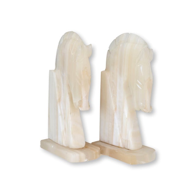 Striking pair of midcentury alabaster bookends carved in the stylized form of chess knights, rendered with bold,...