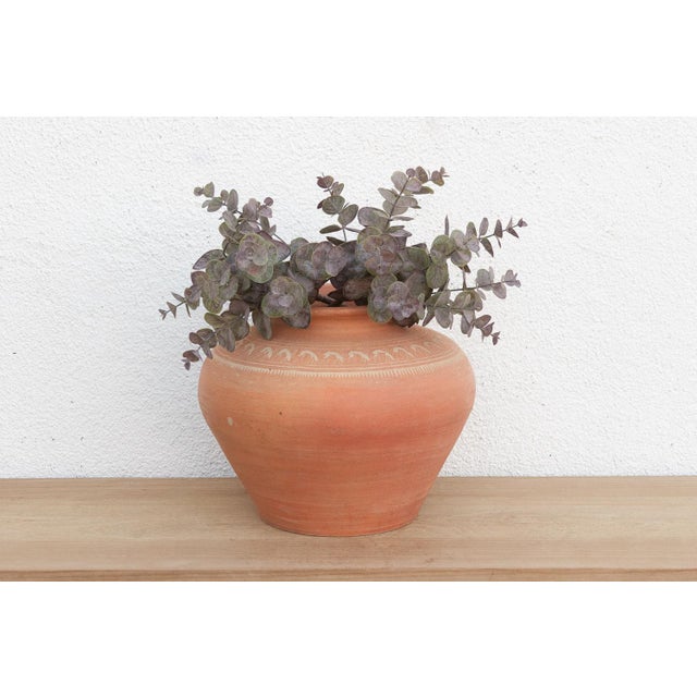 A beautiful example of Southeast Asian village craftsmanship, this bulbous terracotta jar hails from Thailand. It is...