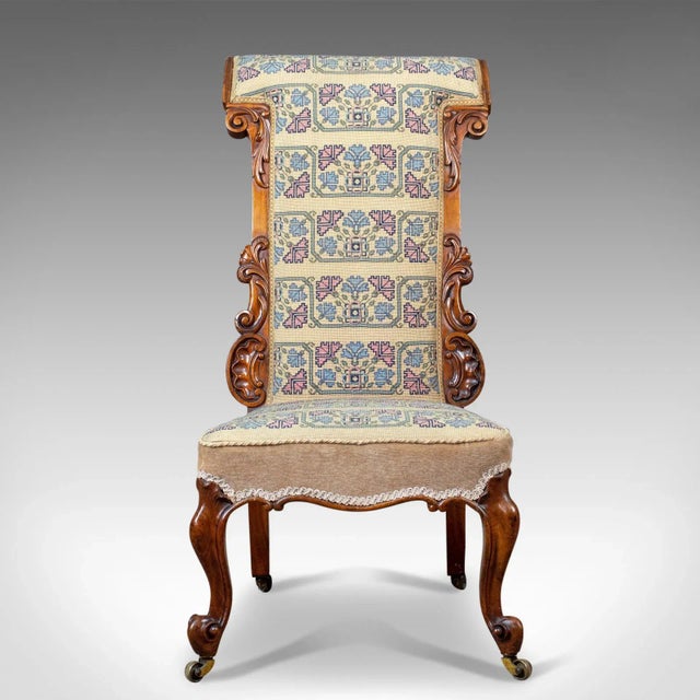 This is an antique prie dieu chair, a 19th century, early Victorian chair in walnut with a needlepoint tapestry seat...