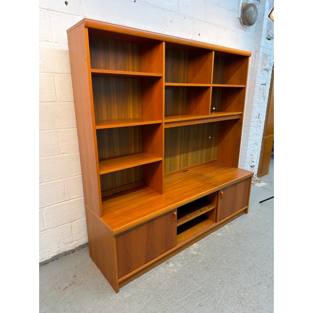 A beautifully crafted Danish Modern shelving unit by Uldum Møbelfabrik, showcasing the warmth and natural beauty of teak....