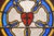 Antique rectangular church window with textured stained glass panels of yellow, amber, brown, and blue colors. The outside...