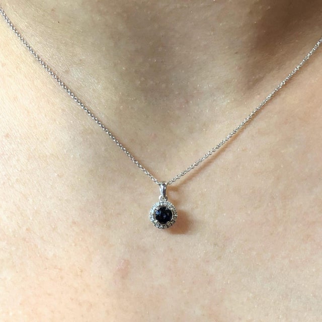 This beautiful pendant features a 0.51 carat round sapphire with a halo of natural earth mined diamonds, all set in solid...
