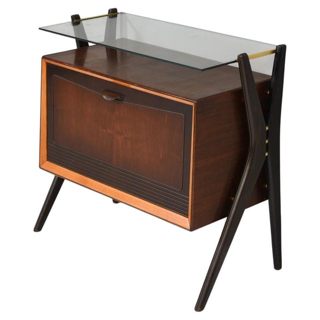 A striking example of italian mid-century design, this elegant bar cabinet combines rich dark walnut tones with sculptural...