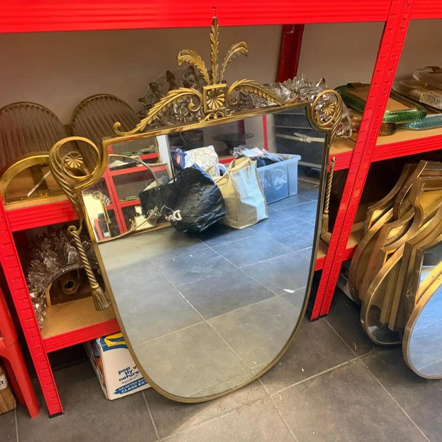 This exceptional 1950s Mid-Century Modern shield wall mirror beautifully captures the elegant, neo-classical-infused...