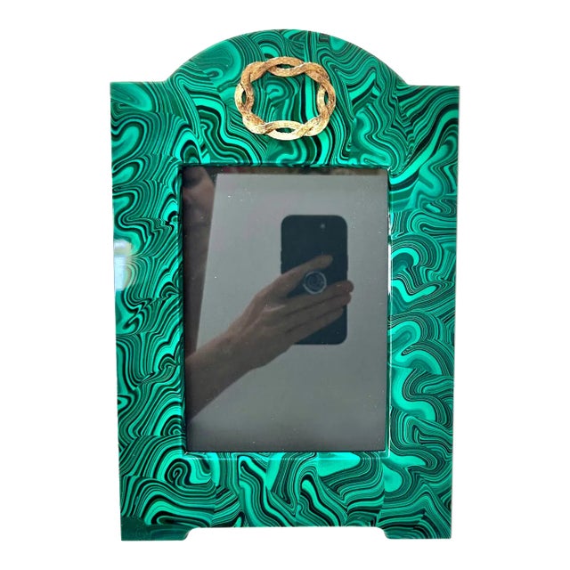 A striking vintage faux-malachite picture frame with vivid emerald-and-black swirls and an ornate brass medallion crest....