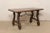 A Spanish walnut wood stretcher table, with beautifully carved lyre legs, from the 18th century. This antique table from...