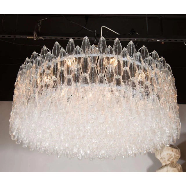 This Italian chandelier consists of numerous polyhedral shades suspended in a complex interlocking cylindrical design. The...