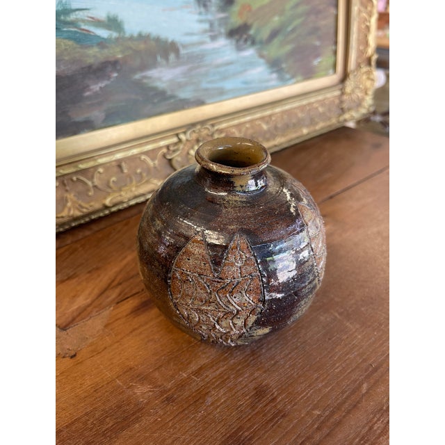 A small hand-thrown studio pottery vase signed "Nelson" on the base. This piece features a bulbous form with a narrow neck...