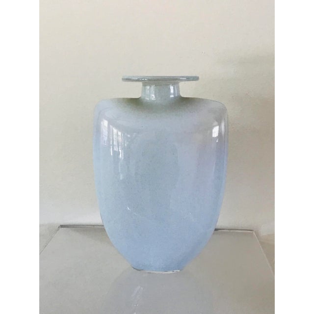 A glass vase with a faint haze of blues and white. Etched on base Kosta Boda and designed by Kjell Engman. Fine glasswork...