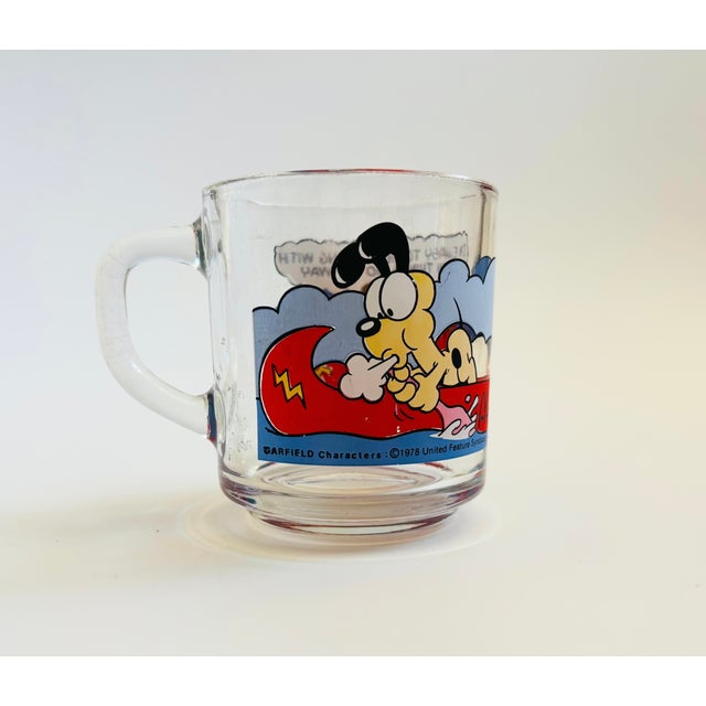 A vintage 1970s Garfield and friends glass mug. Features a colorful printed design. Originally made for McDonalds.