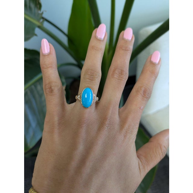 A Sleeping Beauty turquoise in a clean, robin's-egg blue is bezel-set at the centre of this solid 14K yellow gold split-...