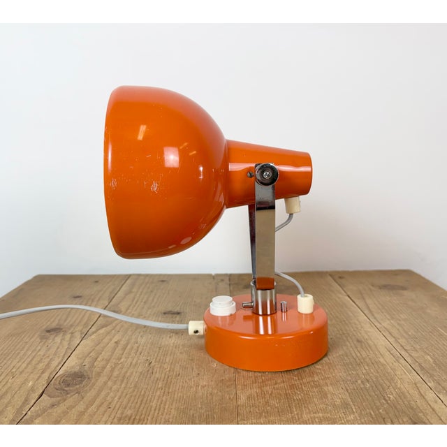 This orange wall light was produced by Lidokov in former Czechoslovakia during the 1970s. The lamp has a iron wall...