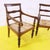 Pair of vintage wooden armchairs featuring woven seats.