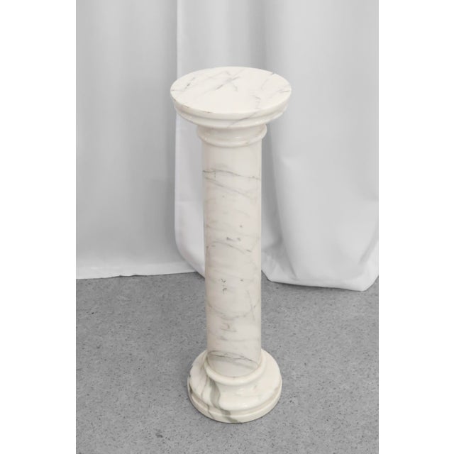 Marble pedestal stand from the 1980s, made of solid marble in soft tones of white and light grey. The stand has a round...